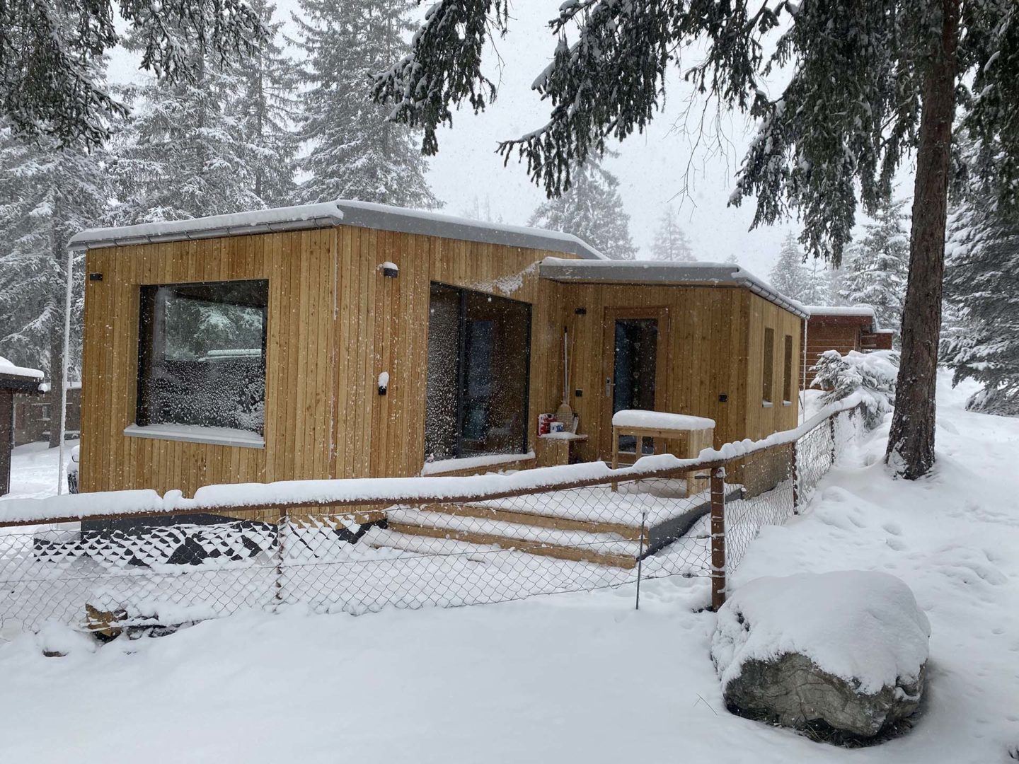 Mini casa in legno sotto la neve