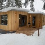 Mini casa in legno sotto la neve