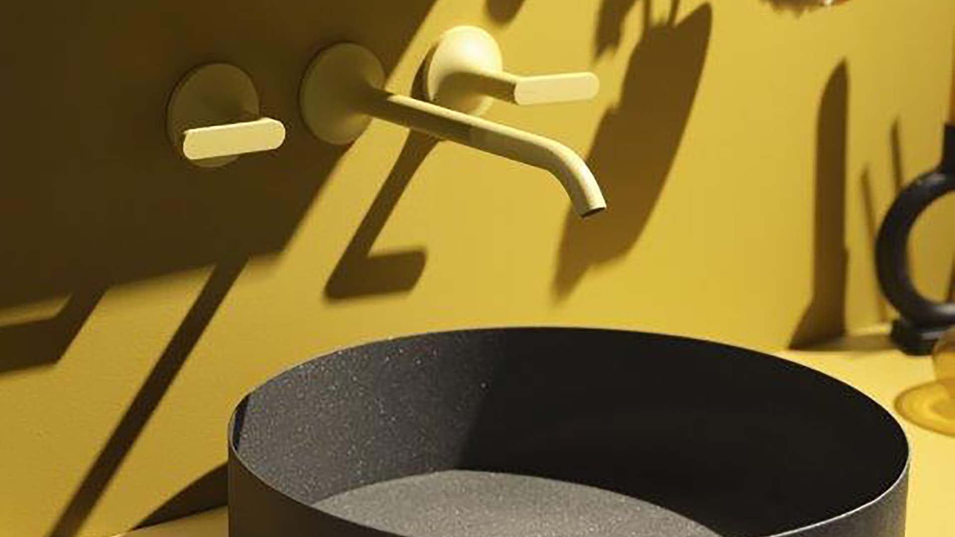 Rubinetto e manopole giallo opaco dal design essenziale (particolare)