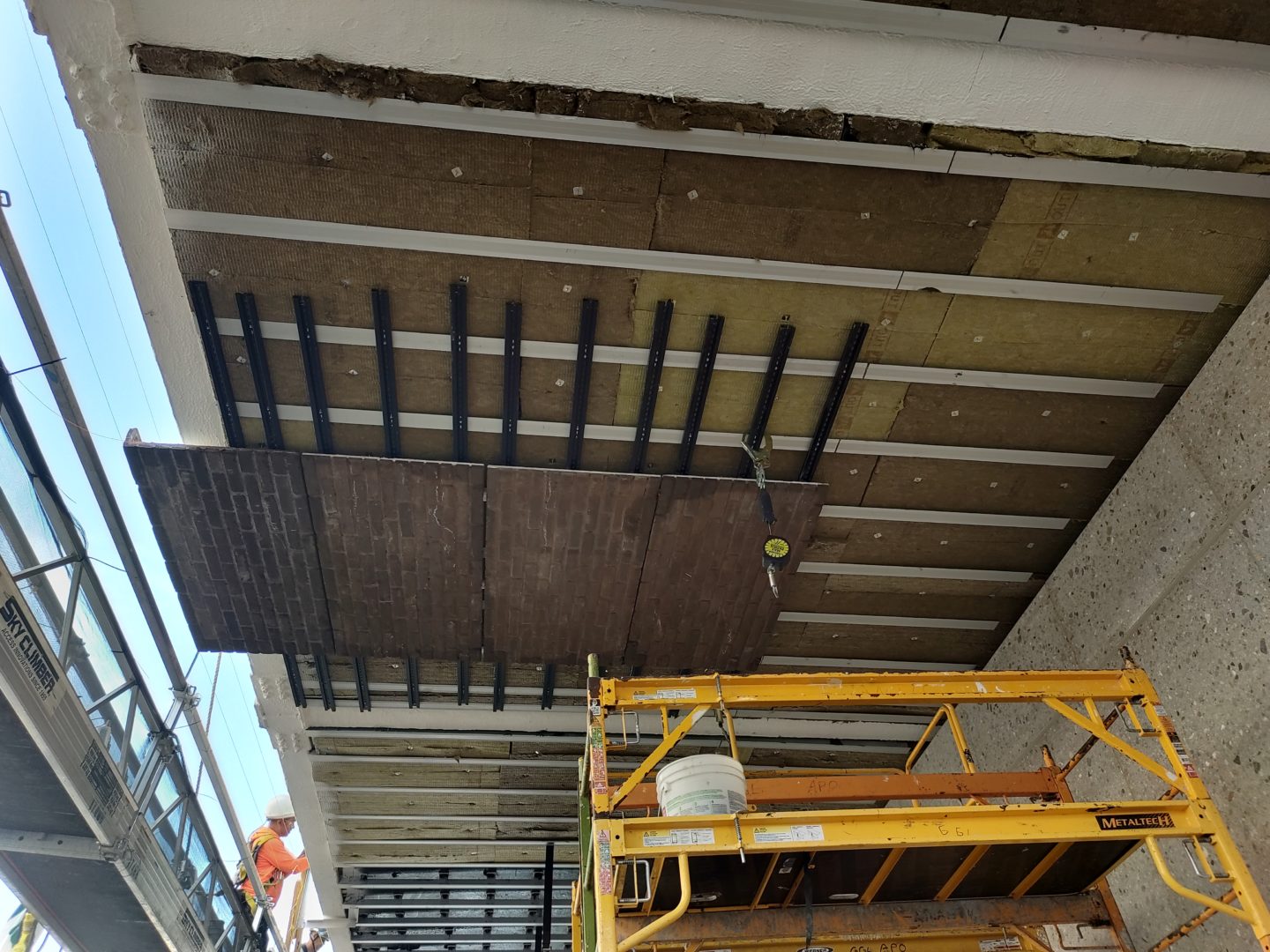 Montaggio dei pannelli in mattoni facciavista in corrispondenza dello sbalzo che sovrasta l’edificio adiacente