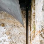 Dettaglio delle volte in lamiera di ferro naturale da 4 millimetri, lasciate a vista, che si adattano alle geometrie irregolari delle strutture in pietra