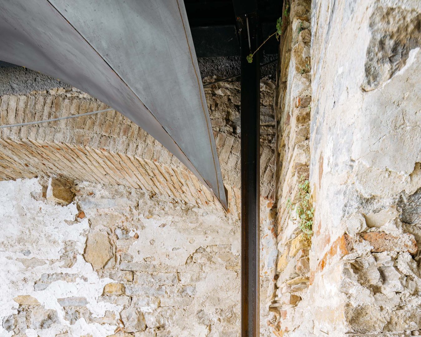 Dettaglio delle volte in lamiera di ferro naturale da 4 millimetri, lasciate a vista, che si adattano alle geometrie irregolari delle strutture in pietra