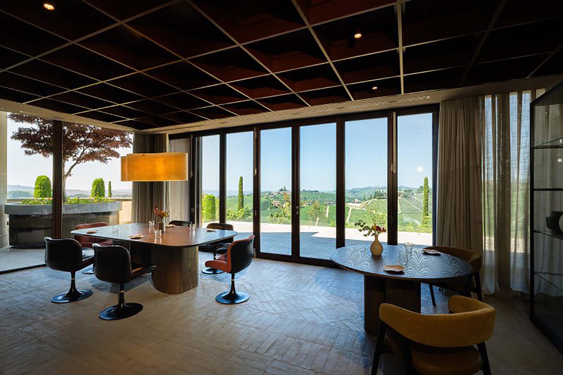 La sala del ristorante con vista sulle Langhe grazie alla finestra scorrevole a libro in legno